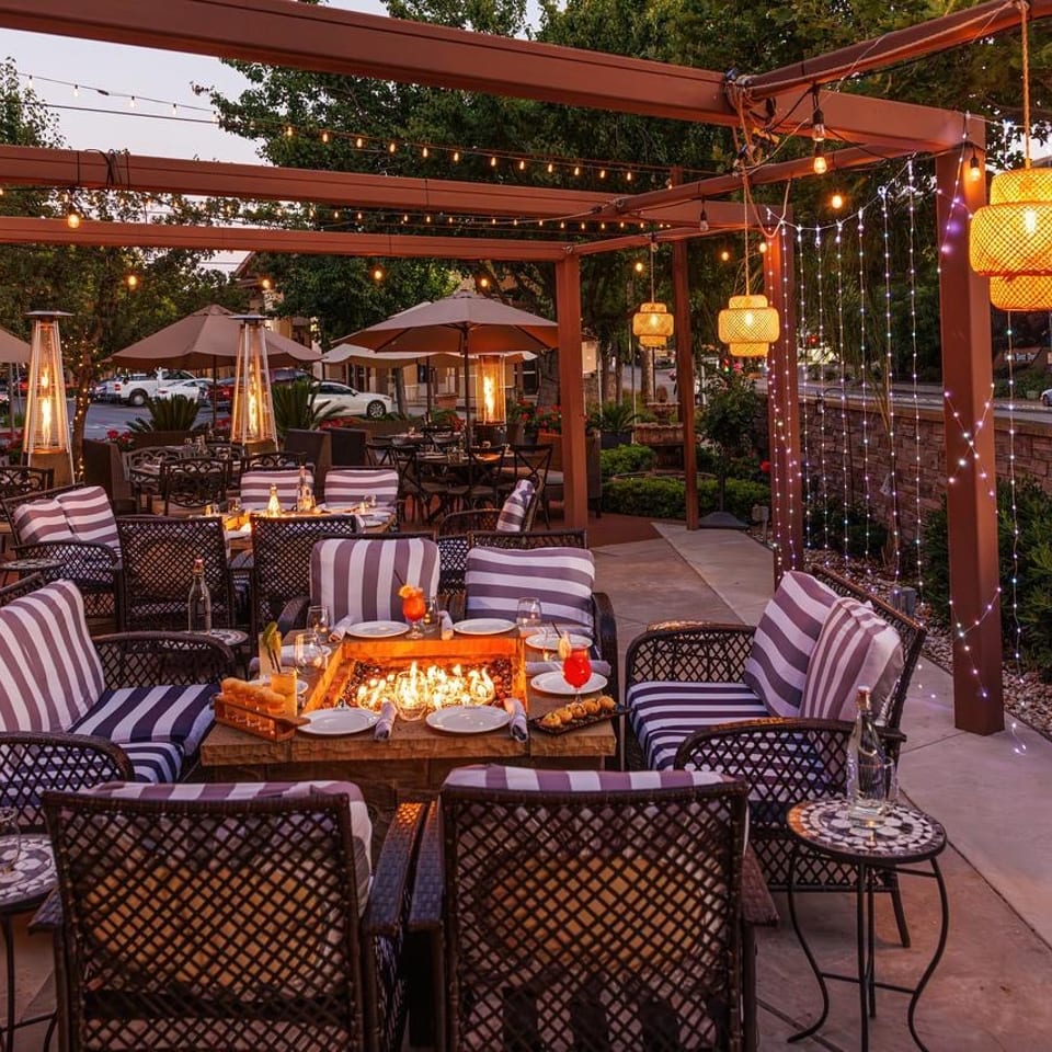 Evening patio with string lights and fire-table seating